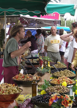 French market stall selling olives, garlic and marinated peppers