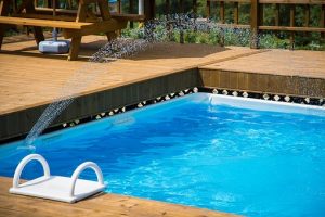 outdoor swimming pool-white steps-blue water-brown floor