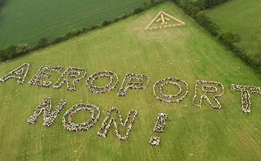 Protesters standing in field making the words 'Aeroport Non'