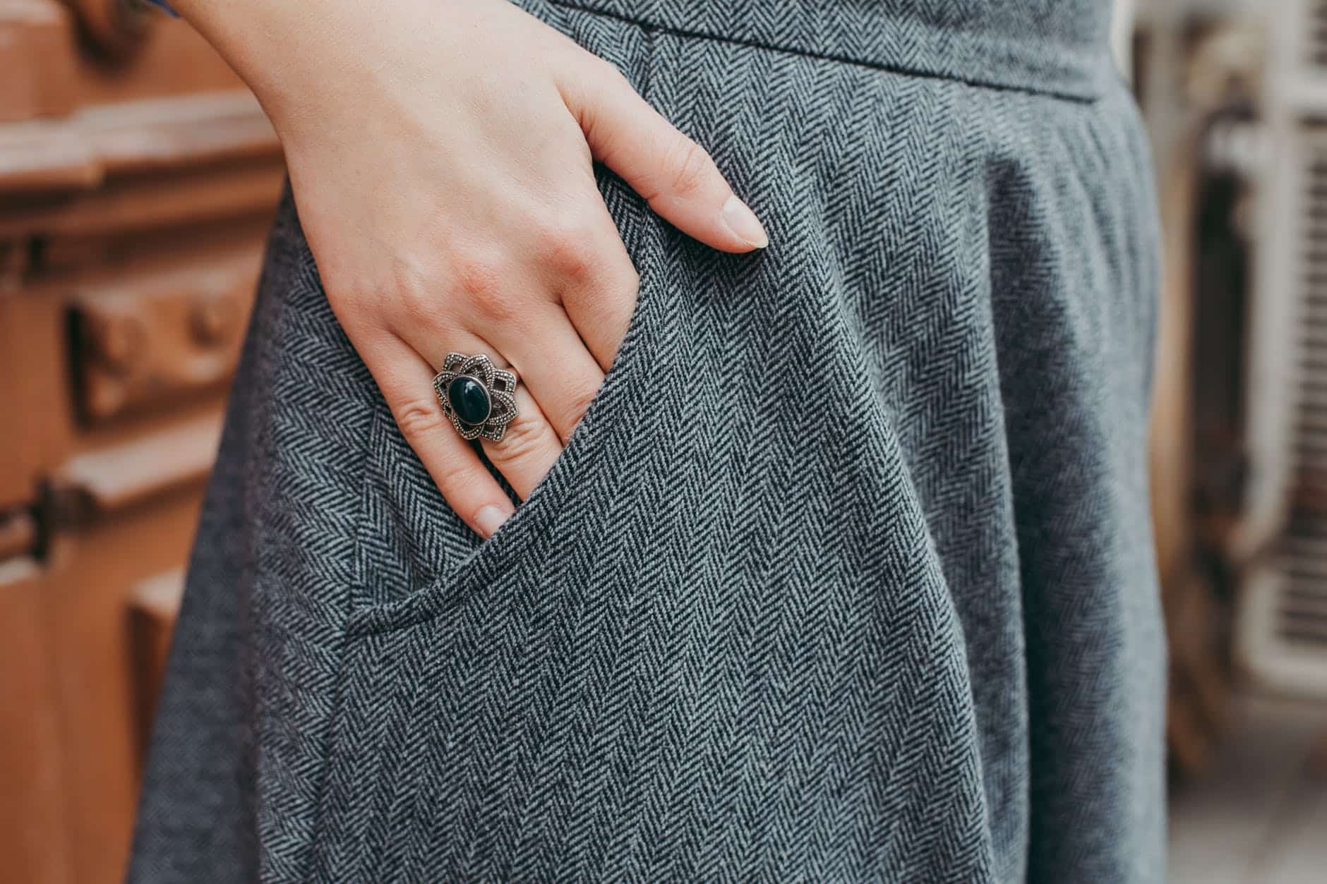 Woman's ringed hand in smart grey trouser pocket