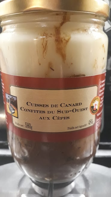 Jar of confit duck legs cooked with ceps