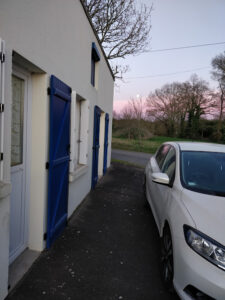 White house with blue shutters in Brittany with white car at the front