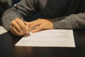 Man filling a form at a table-Bureaucracy