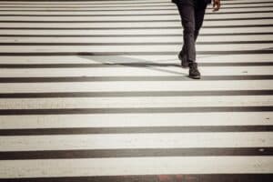 Faceless pedestrian walking on crossing on sunny day